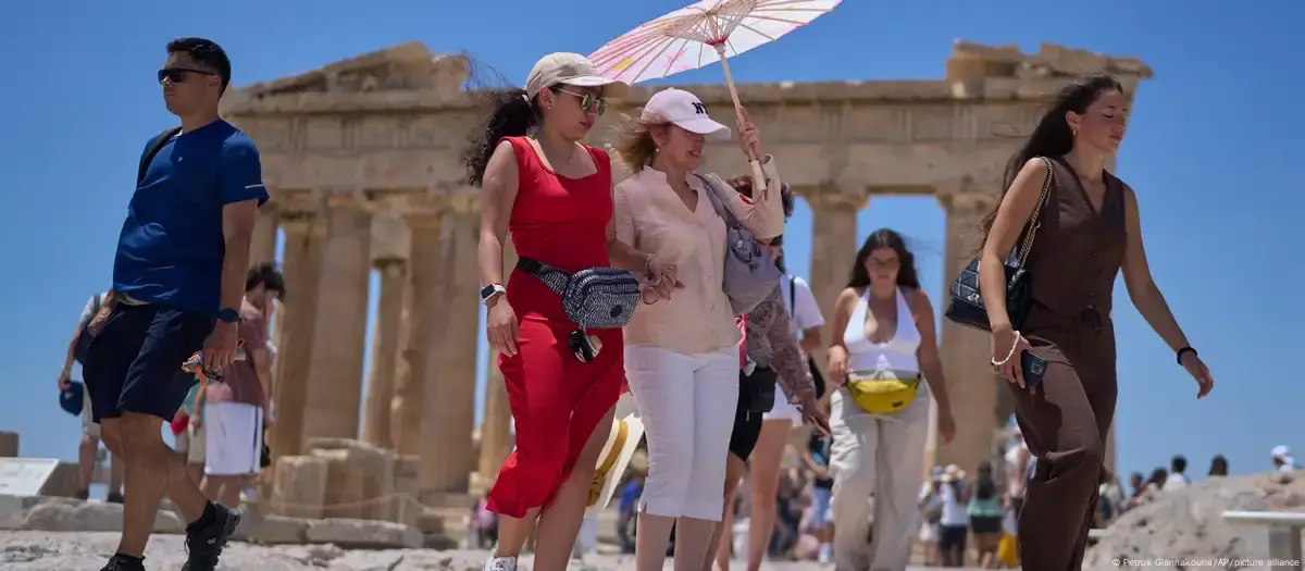صورة رمزية ـ موجة حر استثنائية في أوروبا (سياح يحملون مظلة على تلة الأكروبوليس، أثينا، 26 يونيو 2025)صورة من: Petros Giannakouris/AP/picture alliance